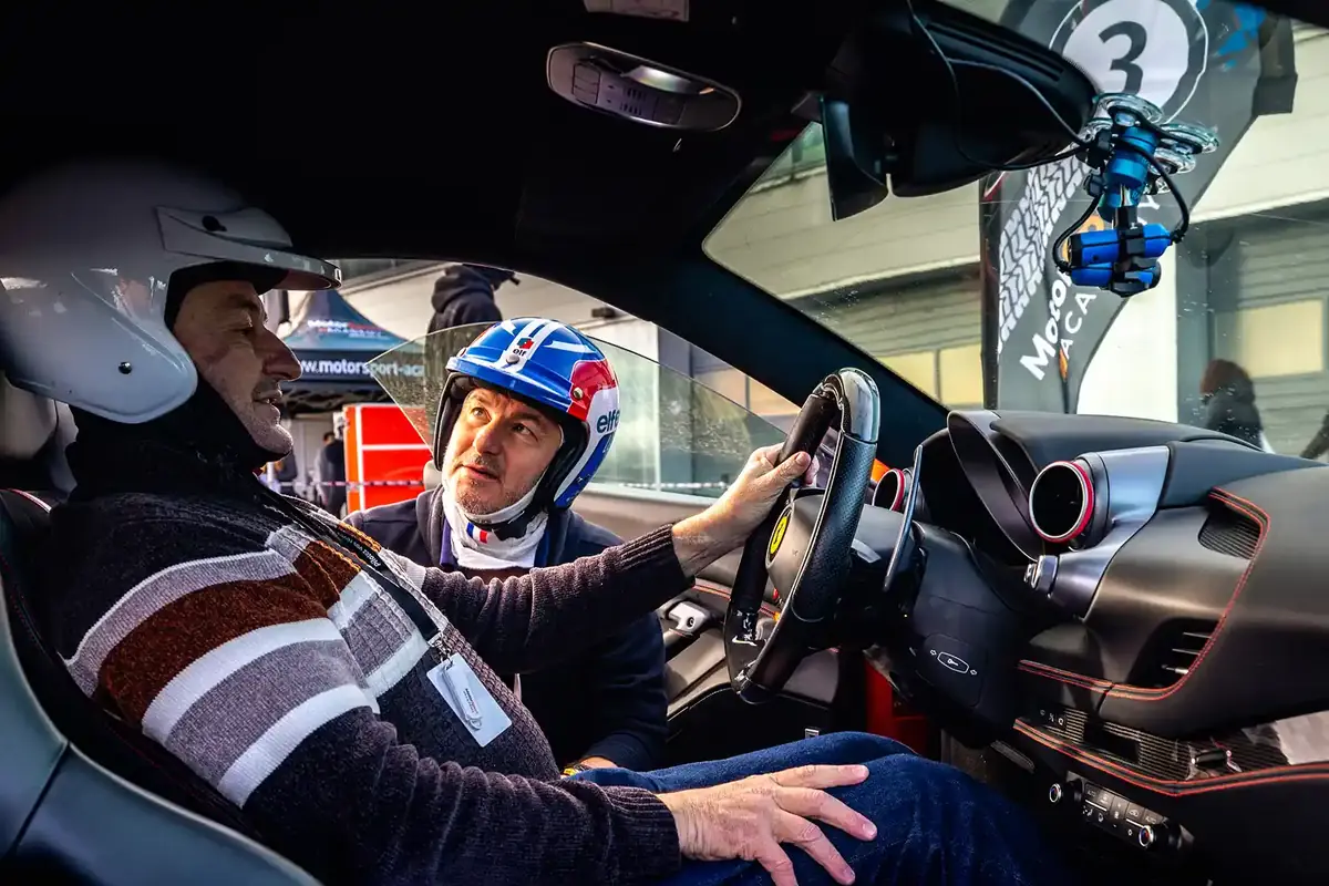 Le pilote et son moniteur installés dans la voiture, casques en place